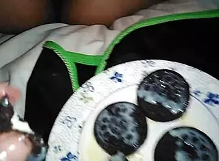 She playfully teases her pussy with an oreo in this fetish scene.