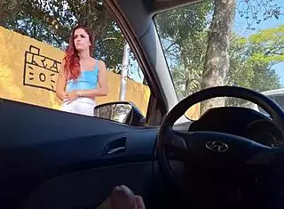 Risky public masturbation by a hot redhead in a miniskirt on the street.
