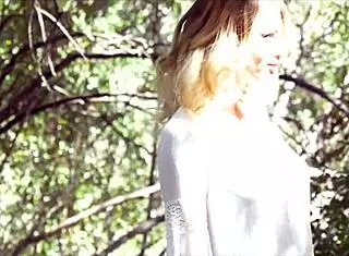 Stunning blonde beauty strips naked between the trees. She masturbates with her natural tits exposed.