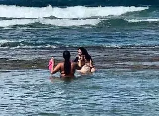 two pretty latinas kiss on public beach first time
