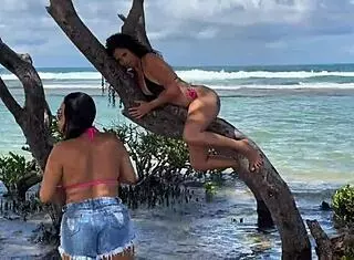 two pretty latinas kiss on public beach first time