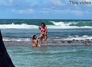 two pretty latinas kiss on public beach first time