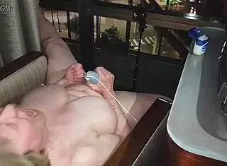 Hey, check out this granny getting naked and masturbating right in front of the city lights at night in a hotel.