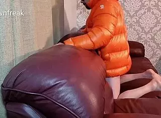 guy humps leather sofa in nylon north face jacket while wanking on bed