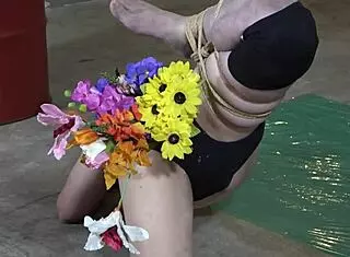 slave arranges flowers deep in anal vase crushing food