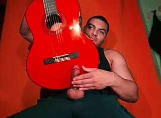 sexy chinese bodybuilder rubs spanish guitar on huge cock over carrot backdrop