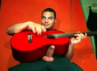 sexy chinese bodybuilder rubs spanish guitar on huge cock over carrot backdrop