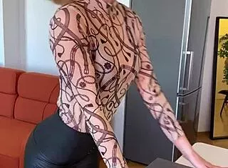 sophie van loo sizzles in grey leggings and heels on kitchen counter.