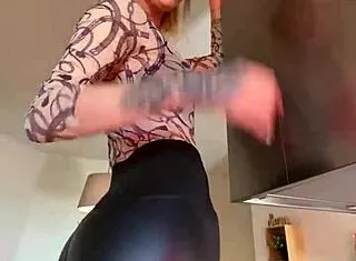 sophie van loo sizzles in grey leggings and heels on kitchen counter.