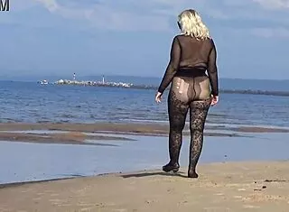 yo this black babe's flashing her big tits and ass all over the beach in public