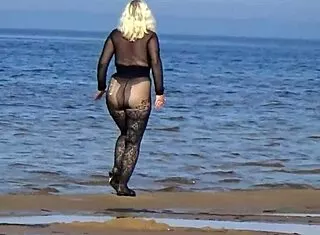 yo this black babe's flashing her big tits and ass all over the beach in public