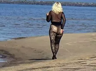 yo this black babe's flashing her big tits and ass all over the beach in public