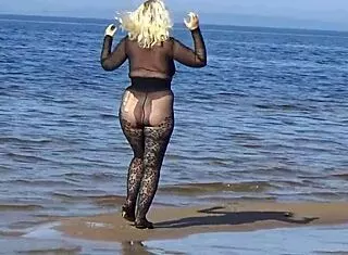 yo this black babe's flashing her big tits and ass all over the beach in public