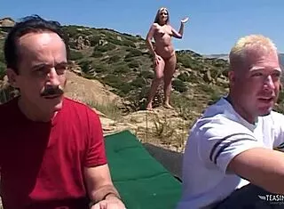 Hot blonde nudist takes two huge cocks beachside!