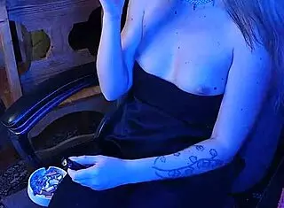 Dominant mistress lights cigarette in private room