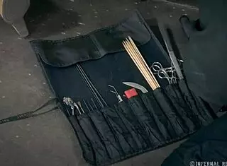 Petite brunette bound in metal bondage for whipping and fingering.