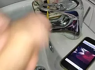 gardener discovers boss's iphone, jerks off in bathroom after finding her xv�deos page while she washes dishes in kitchen