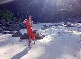 Naked redhead bathes on public beach.