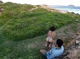 young girl giving blowjob on rocks by the sea