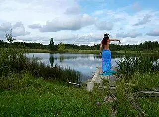 Mature lady poses in bikini on lake