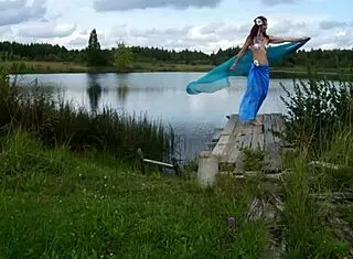 Mature lady poses in bikini on lake