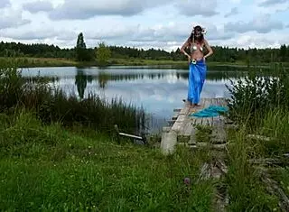 Mature lady poses in bikini on lake