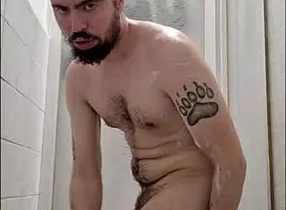 Young hairy twink bathing in shower, stroking fat cock suggestively