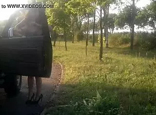 Woman dances naked in public on a pitstop street.