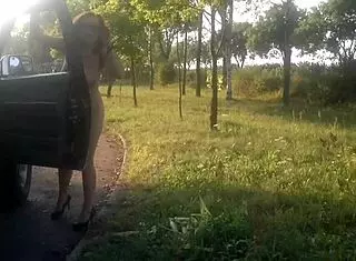 Woman dances naked in public on a pitstop street.