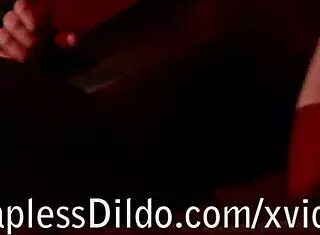 In the shadow, Realdoe enjoys a solo session with strapon in catsuit.