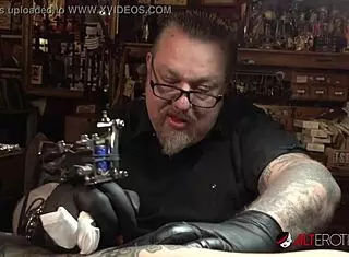 Marie Bossette endures painful tattoo on her leg while exposing pussy and big tits