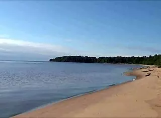 Pretty blonde woman relaxes on the beach with shaved body