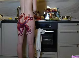 naked housewife with octopus tattoo cooks dinner in kitchen, ignoring you