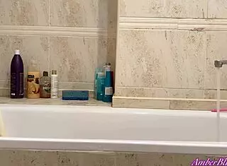 Blonde teen masturbates her pussy to orgasm in the bathroom, showing natural tits and ass.