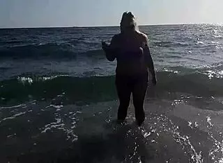 Horny milf masturbates pussy on public beach