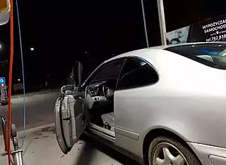 Transsexual washes cars outdoors in public.