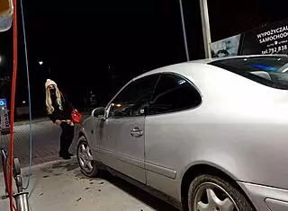 Transsexual washes cars outdoors in public.