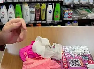 Asian ladyboy displays new thong in stockings at store.