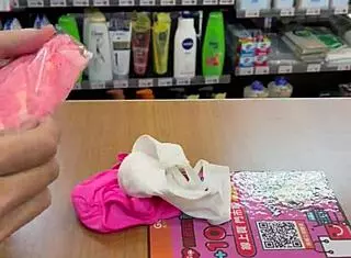 Asian ladyboy displays new thong in stockings at store.