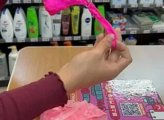 Asian ladyboy displays new thong in stockings at store.